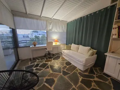 a living room with a couch and a desk at The-terrace-of-glyfada in Athens