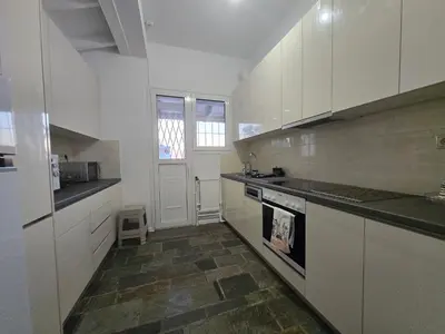 a kitchen with white cabinets and a stove top oven at The-terrace-of-glyfada in Athens