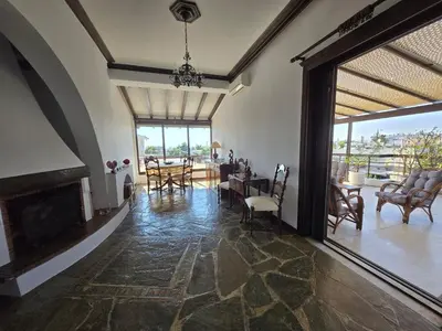 a living room with a fireplace and a table and chairs at The-terrace-of-glyfada in Athens