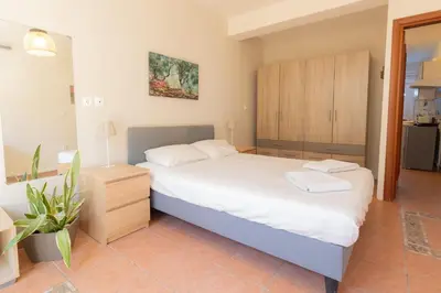 a bedroom with a large bed with white sheets at Alexandra's apartment in Porto Rafti