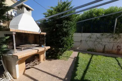 a barbecue grill sitting in the backyard of a house at Alexandra's apartment in Porto Rafti