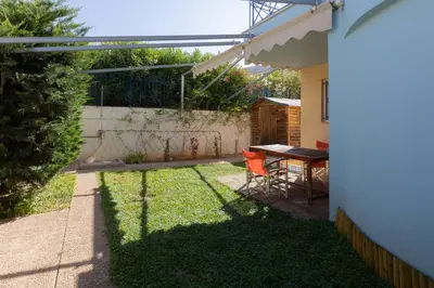 a backyard with a table and chairs and a fence at Alexandra's apartment in Porto Rafti