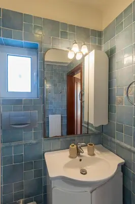 a bathroom with a sink and a mirror at Alexandra's apartment in Porto Rafti