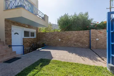 a house with a garage and a brick wall at Alexandra's apartment in Porto Rafti
