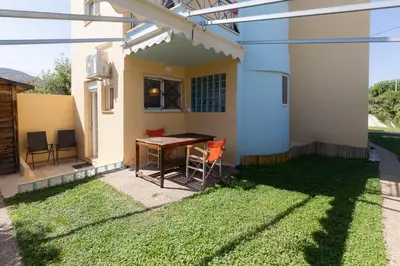 a patio with a table and chairs in a yard at Alexandra's apartment in Porto Rafti