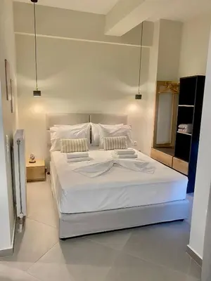 a bedroom with a large bed with white sheets and pillows at ATHENIAN Vibes in Athens