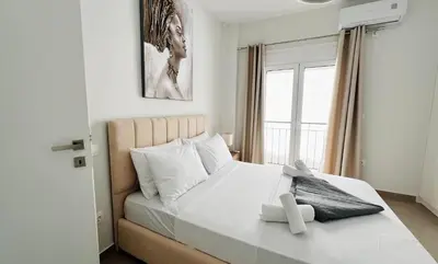 a bedroom with a large white bed with a window at Fifth Sense in Athens by ΜPS in Athens