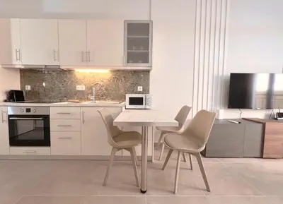 a white kitchen with a table and chairs in it at Fifth Sense in Athens by ΜPS in Athens