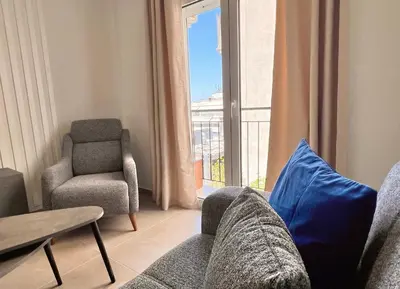 a living room with a couch and a chair and a window at Fifth Sense in Athens by ΜPS in Athens
