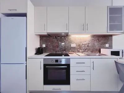 a white kitchen with a stove and a sink at Fifth Sense in Athens by ΜPS in Athens