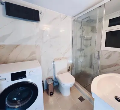 a bathroom with a washing machine and a toilet at Fifth Sense in Athens by ΜPS in Athens