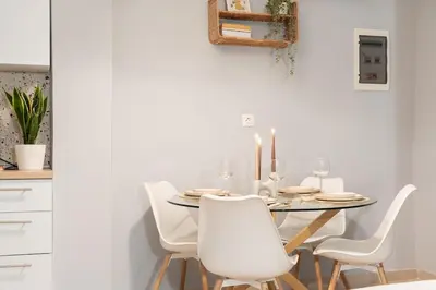 a white dining room with a table and white chairs at Joo Nest - Your home near Piraeus Port in Piraeus