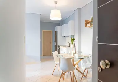 a kitchen and dining room with a table and chairs at Joo Nest - Your home near Piraeus Port in Piraeus