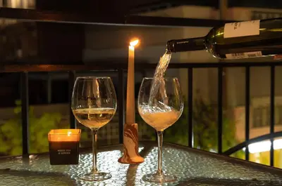 a bottle of wine being poured into two wine glasses at Joo Nest - Your home near Piraeus Port in Piraeus