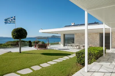 a porch of a house with a view of the ocean at Paradise Beachfront Villa Athenian Riviera in Aghia Marina