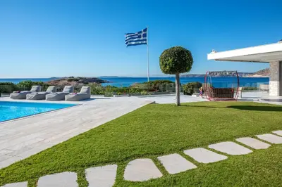 a house with a swimming pool and a playground at Paradise Beachfront Villa Athenian Riviera in Aghia Marina