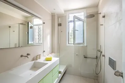 a white bathroom with a sink and a shower at Paradise Beachfront Villa Athenian Riviera in Aghia Marina