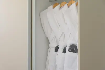 a row of white towels hanging in a closet at Athenean Private Pool Heaven in Athens