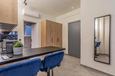 a kitchen with a counter and blue chairs in a room at Luxurius Studio Near Plaka & Acropolis 4 in Athens