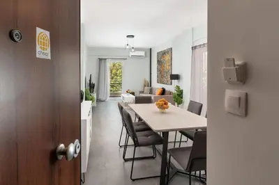 a dining room and living room with a table and chairs at Aera Nest - 2BR, Alimos in Athens