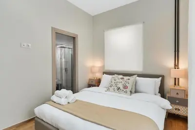 a bedroom with a large white bed with two lamps at Aera Nest - 2BR, Alimos in Athens