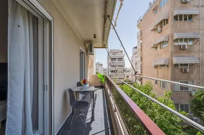 a balcony with a table and a chair on a building at Aera Nest - 2BR, Alimos in Athens