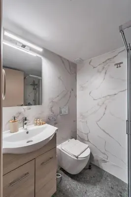 a white bathroom with a sink and a toilet at Aera Nest - 2BR, Alimos in Athens