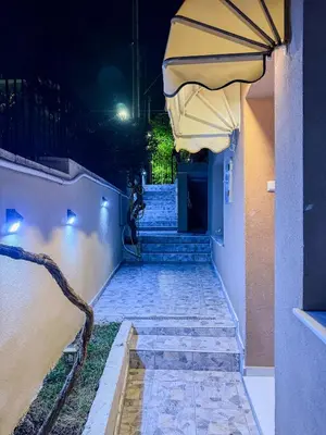a person sitting on the stairs of a building at night at Aphrodite Apartment in Athens