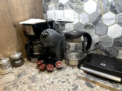 a counter top with a coffee maker and cupcakes at Aphrodite Apartment in Athens