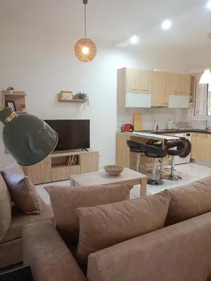 a living room with a couch and a kitchen at Keep it simple Athens in Athens