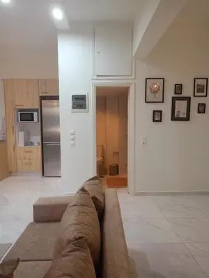 a living room with a couch and a kitchen at Keep it simple Athens in Athens