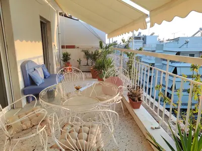 a balcony with a glass table and chairs at Mediterranean Penthouse in the center of Athens in Athens