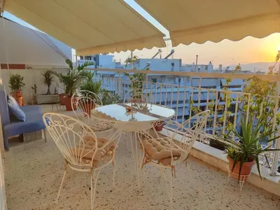 a patio with a table and chairs on a balcony at Mediterranean Penthouse in the center of Athens in Athens