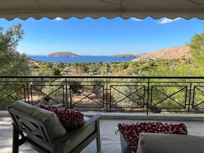 a room with a chair and a view of the ocean at Seaview Haven in Sounio