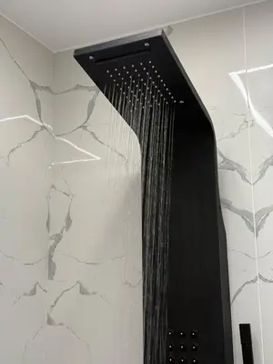 a shower with a black shower head on a wall at S&P-elegant suite with jacuzzi in Athens