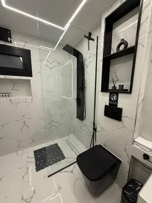 a bathroom with a glass shower with a toilet at S&P-elegant suite with jacuzzi in Athens