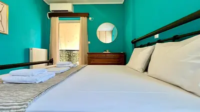 a bedroom with green walls and a bed with two towels at Seaside Central 3bdr Apt with sea views in Athens