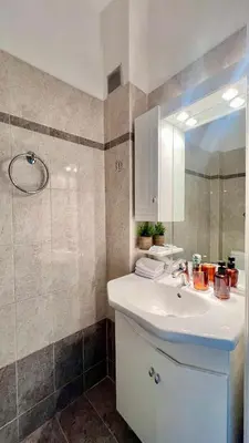 a bathroom with a sink and a mirror and a shower at Seaside Central 3bdr Apt with sea views in Athens