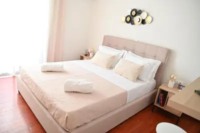 a bedroom with a large bed with white sheets and pillows at Athénée Retreat in Athens