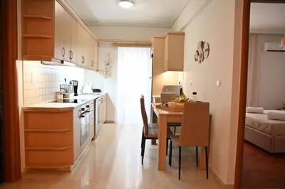 a kitchen and dining room with a table and a kitchen and a room at Athénée Retreat in Athens
