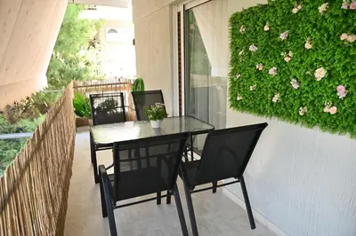 a table and chairs on a balcony with flowers at Athénée Retreat in Athens