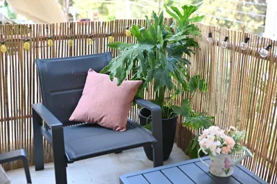 a black chair with a pink pillow on a patio at Athénée Retreat in Athens