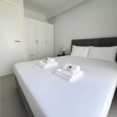 a white bed with two towels on top of it at Minimal City Retreat in Western Athens in Athens