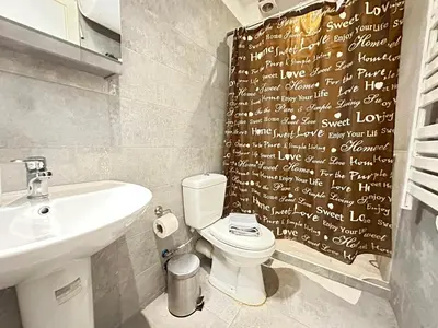 a bathroom with a toilet and a sink and a shower curtain at Minimal City Retreat in Western Athens in Athens
