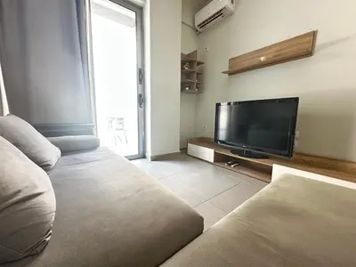 a living room with a couch and a flat screen tv at Minimal City Retreat in Western Athens in Athens