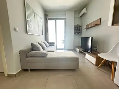 a living room with a couch and a tv at Minimal City Retreat in Western Athens in Athens