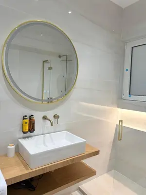 a white bathroom with a sink and a mirror at The Kallion Kolonaki Athens in Athens
