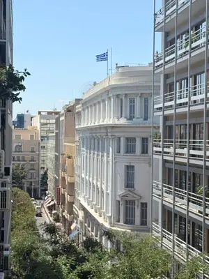 a white building with a flag on top of it at The Kallion Kolonaki Athens in Athens