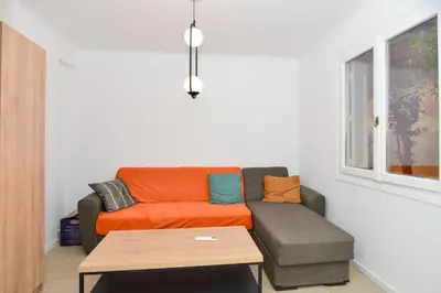 a living room with a couch and a table at Athenian Riviera budget friendly 2 minutes to the beach tram in Athens