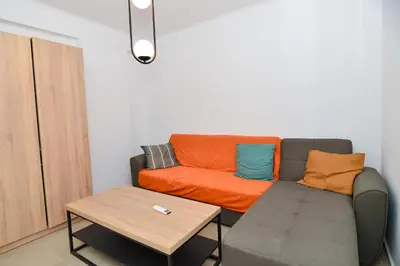 a living room with a couch and a table at Athenian Riviera budget friendly 2 minutes to the beach tram in Athens